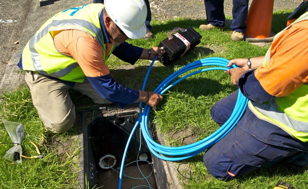 Workers lay fibre-optic cable as part of the NBN rollout. 